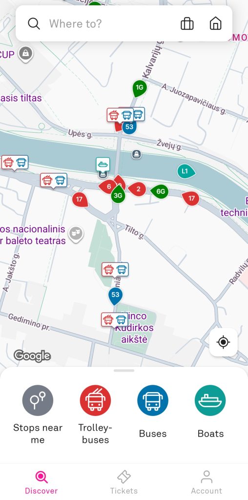 A Trafi app map of central Vilnius shows live vehicle markers for buses in blue, express buses in green, trolleybuses in red, and boats in teal. The screen also shows options for "Stops near me", "Trolleybuses", "Buses" and "Boats".