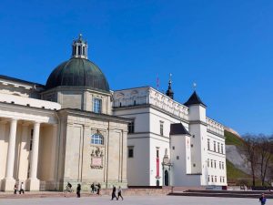 The Palace of the Grand Dukes and Vilnius Cathedral beside Cathedral Square under a clear blue sky.