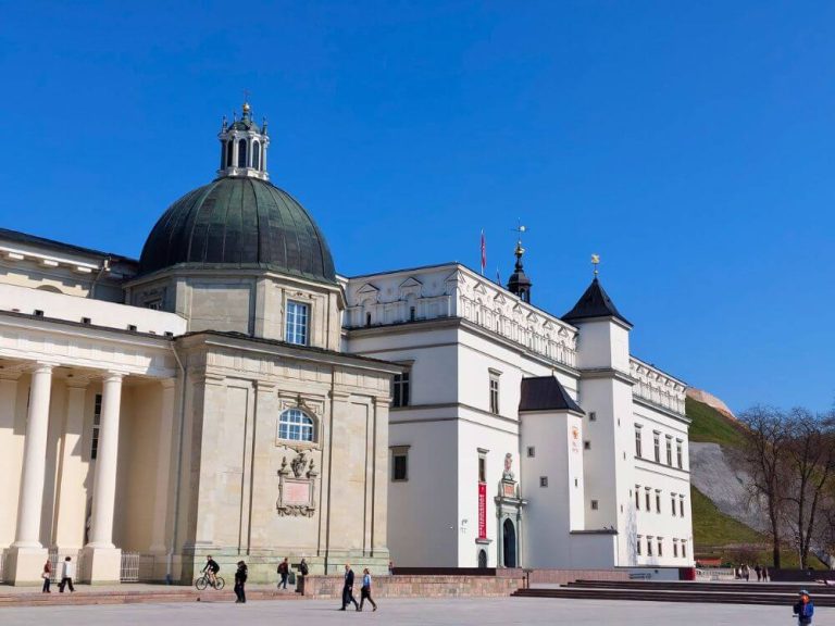 The Palace of the Grand Dukes and Vilnius Cathedral beside Cathedral Square under a clear blue sky.